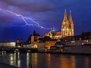 Eine stimmungsvolle Ansicht von Regensburg mit Dom während eines Gewitters mit Blitz